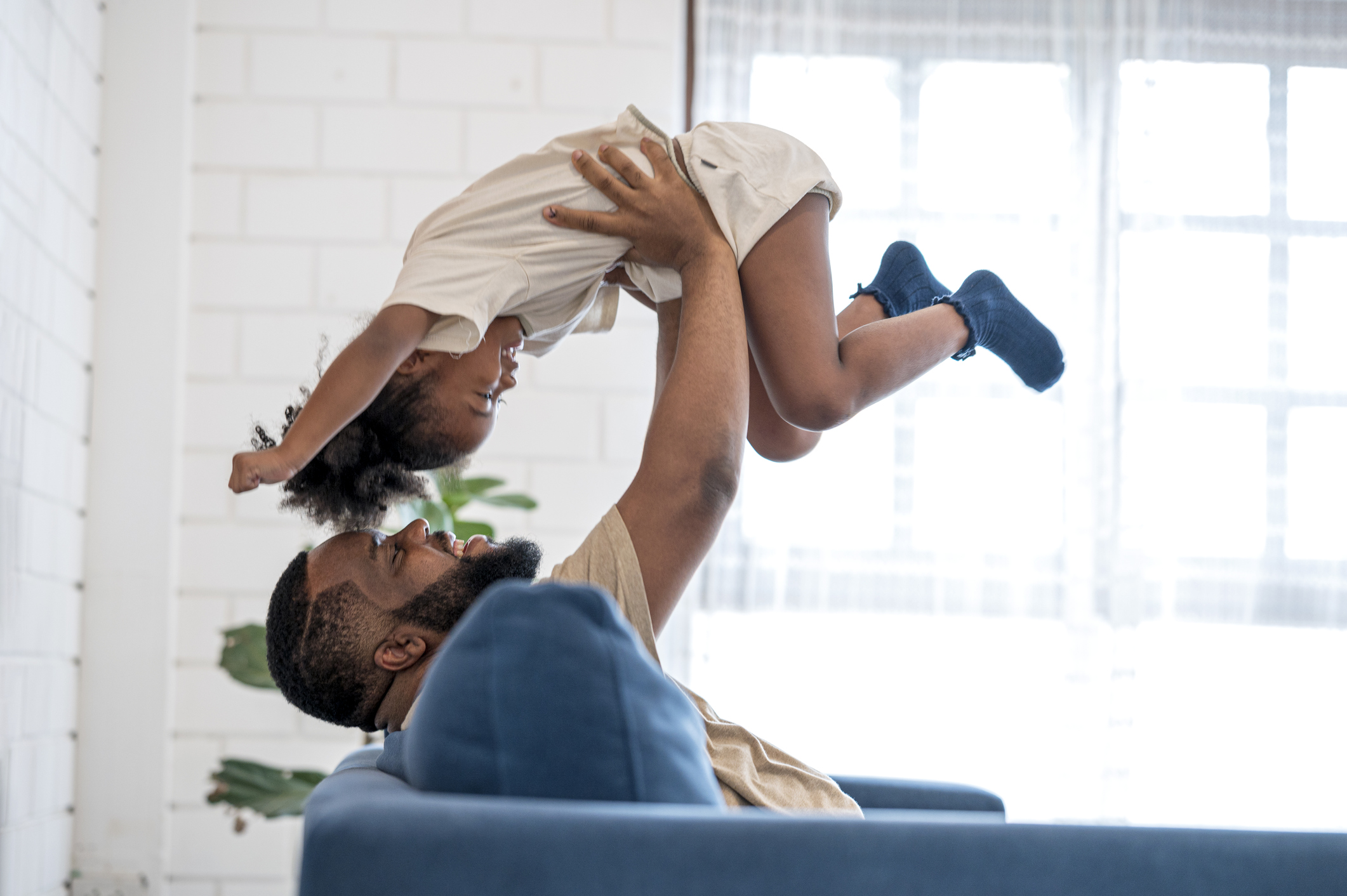 A man playing with his child after taking out a life insurance policy