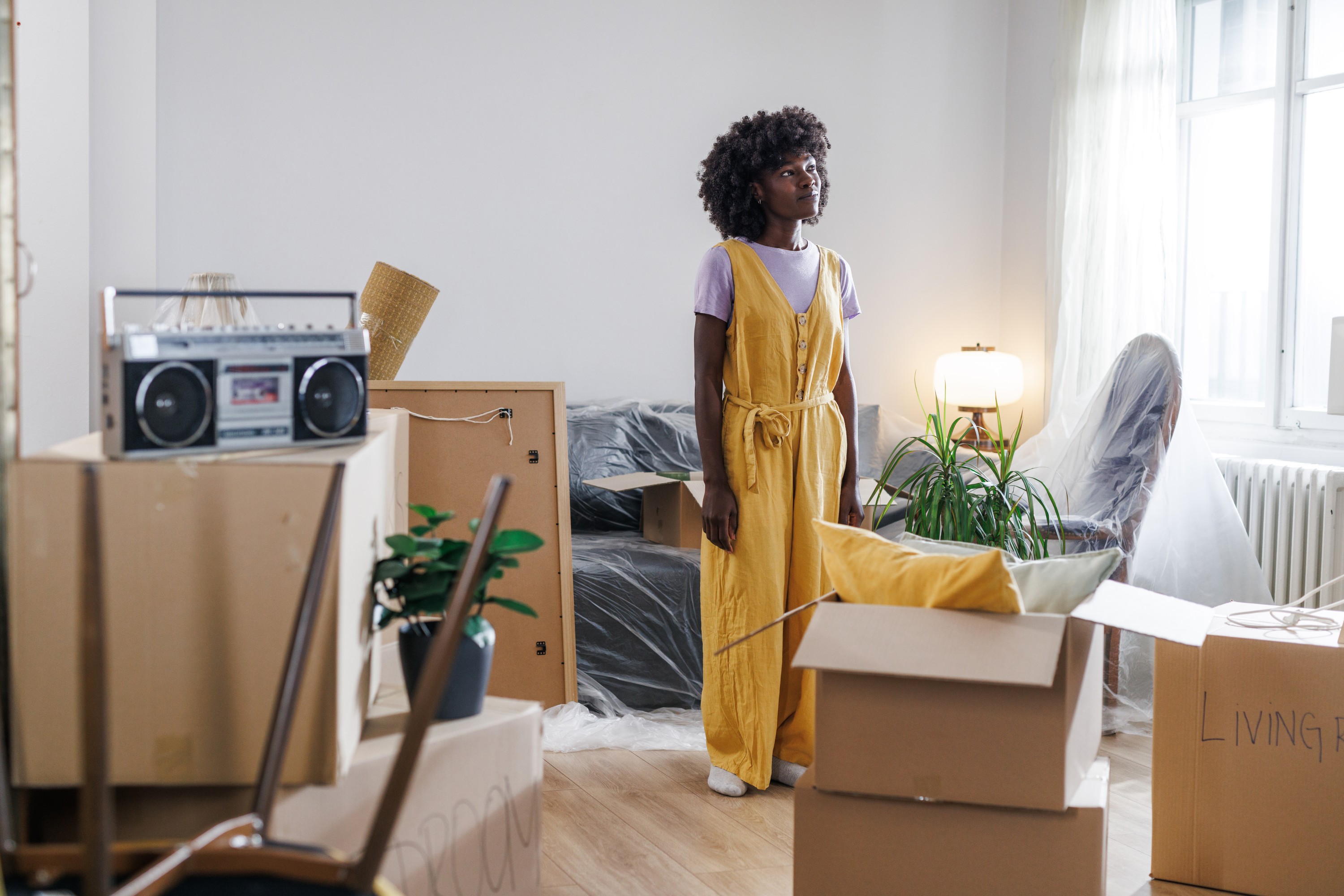 Woman standing among moving boxes stuck in a mortgage chain