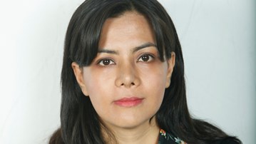 Portrait picture of woman with brown hair in front of a white background