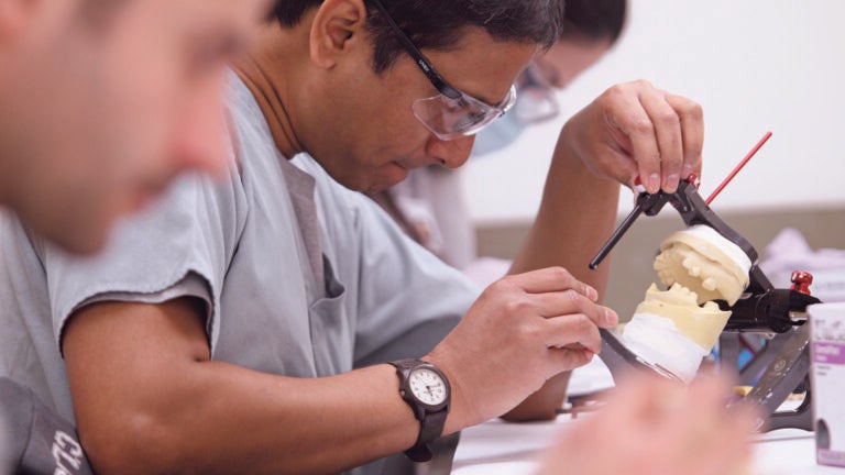 Dentist working on a set of dentures for a patient.