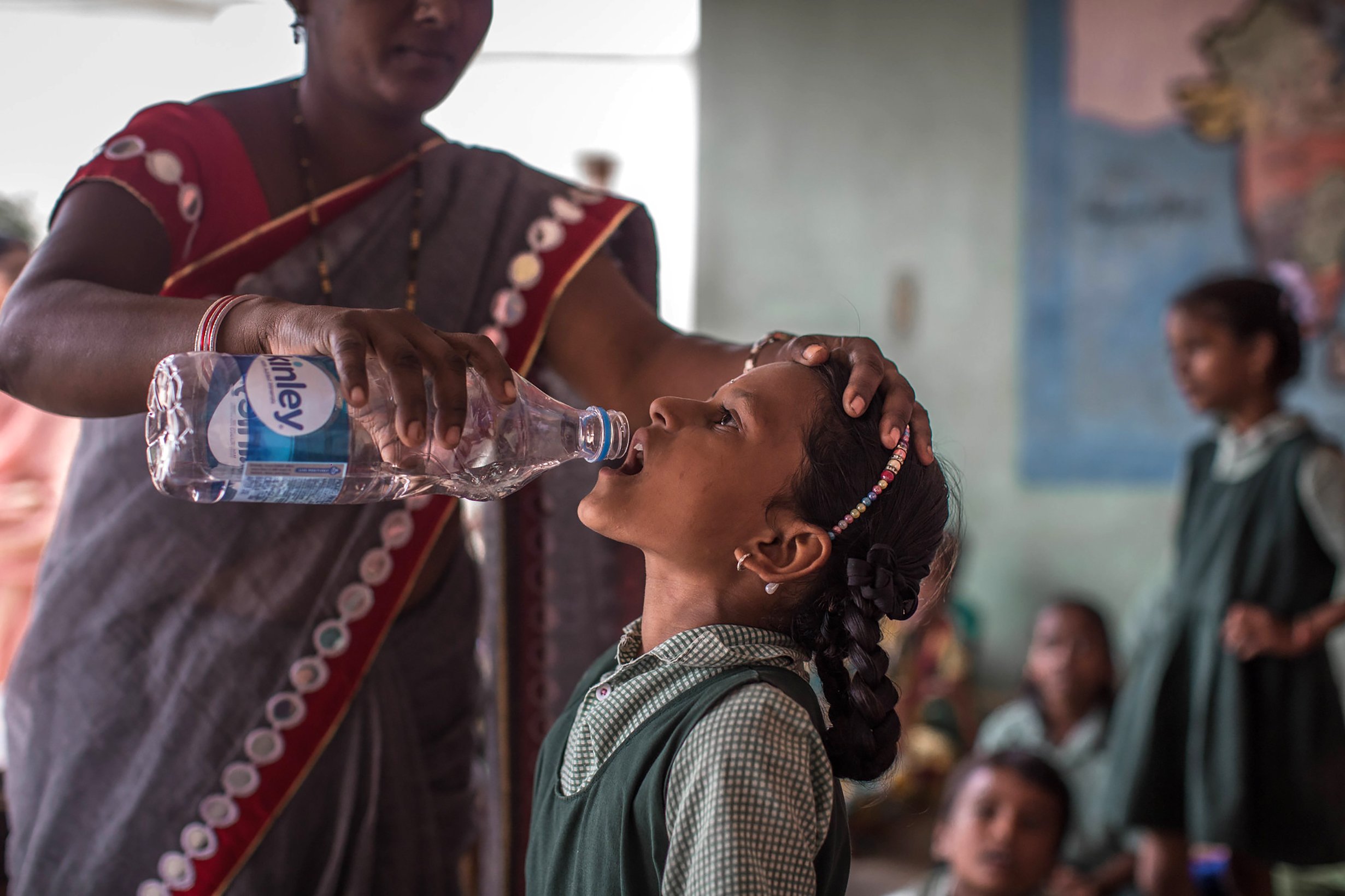 A teacher administers deworming medication at a school deworming day in Hyderabad.