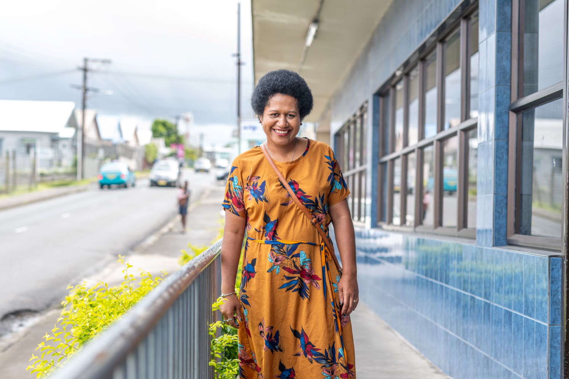 Portrait of Divisional Nurse Coordinator, Udila Tawake, in front of the Ministry of Health in Suva, Fiji.