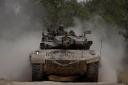 Israeli soldiers move on the top of a tank near the Israeli-Gaza border (AP)