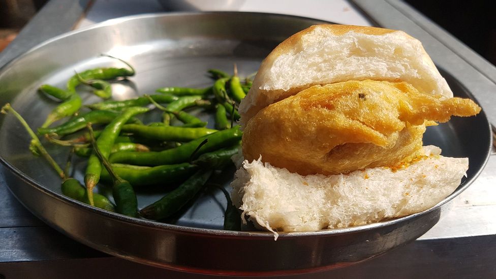 Vada pav is a deep-fried potato patty served on a soft bread roll with spicy green chilli (Credit: Charukesi Ramadurai)