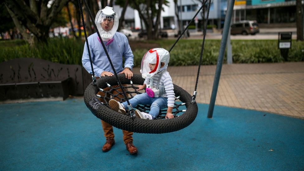 Man and child with anti-Covid helmets (Credit: Anadolu Agency/Getty Images)