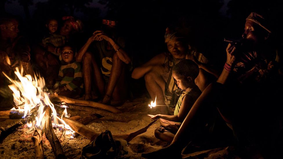 Sharing stories around a fire after dark is common in many non-industrial societies (Credit: Jorge Fernández/Getty Images)