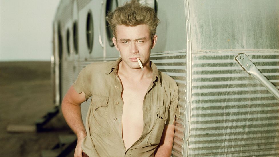 Actor James Dean learning against a trailer on the set of the film Giant (Credit: Getty Images)