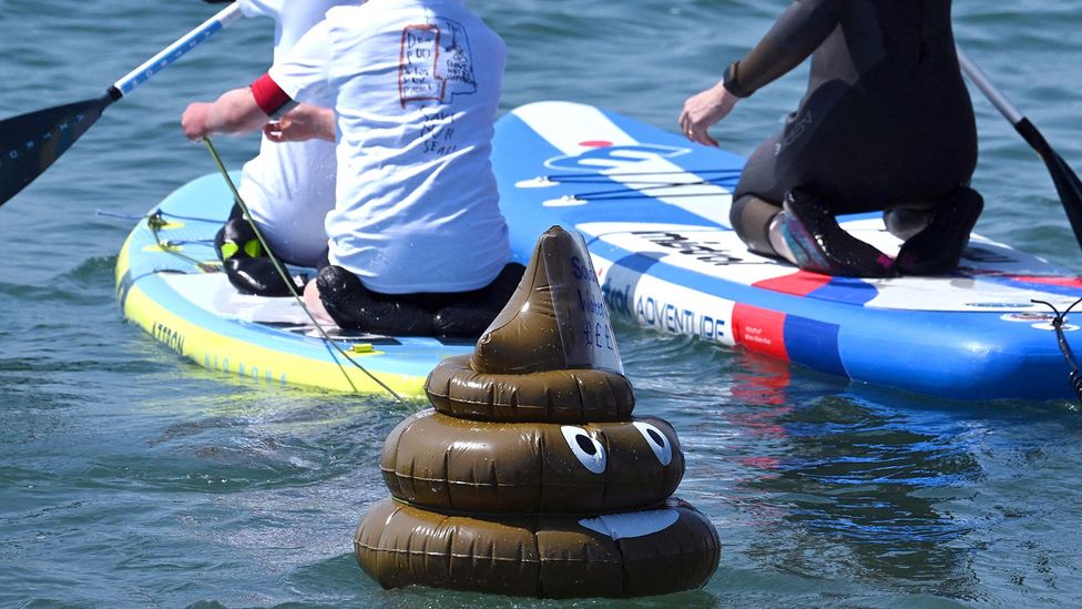 An inflatable poo on a lack in front of paddleboarders (Credit: Getty Images)